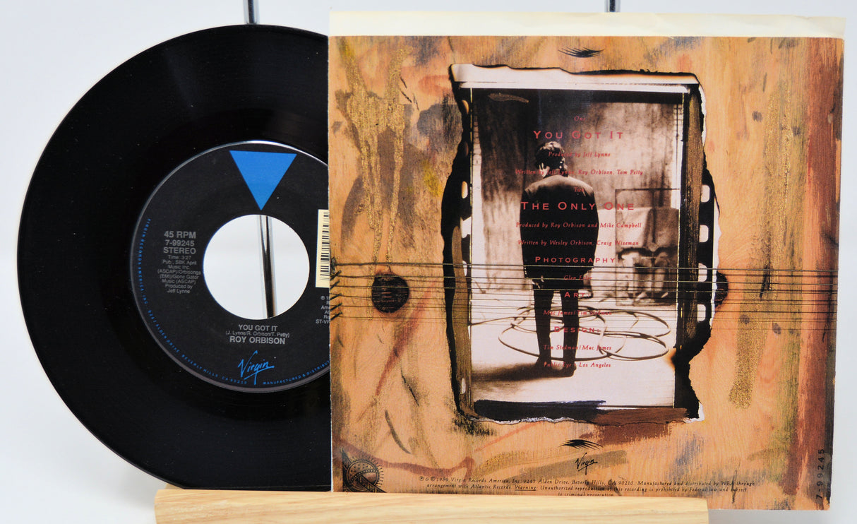 Vinyl record with cover featuring a person playing guitar, on a white background