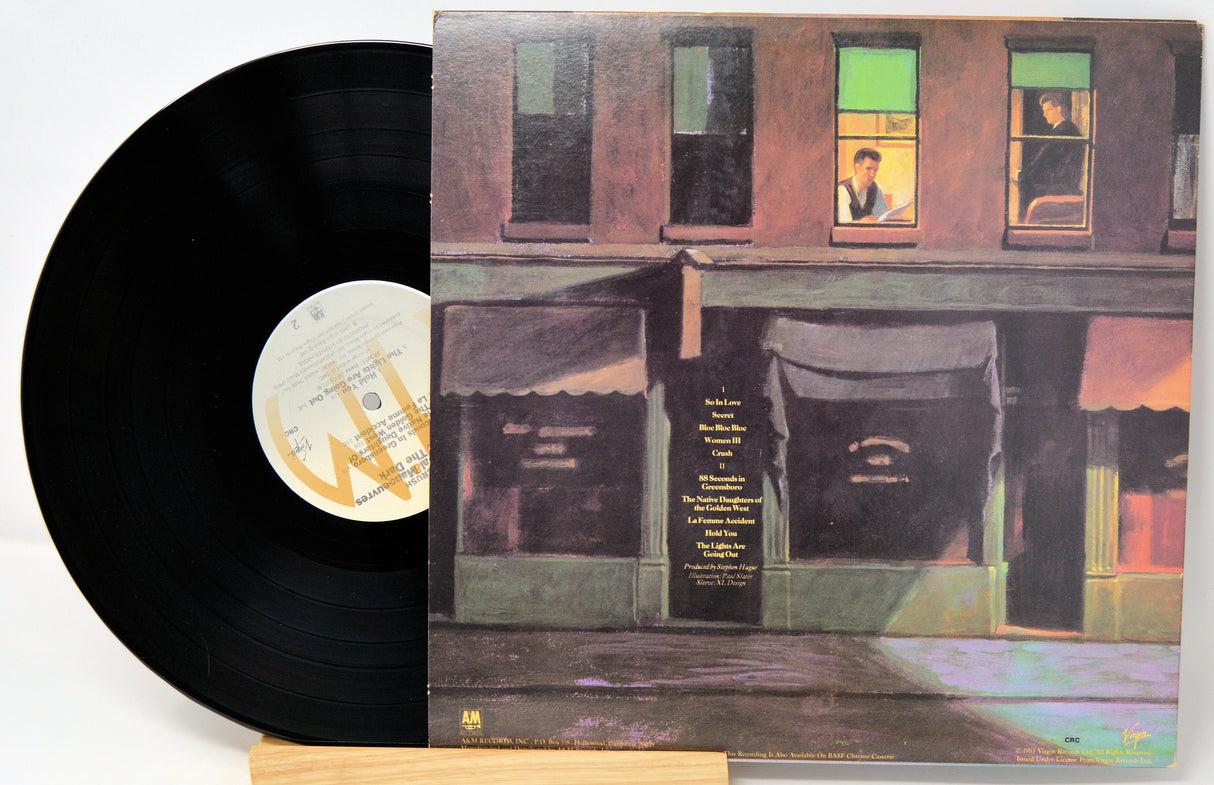 Vinyl record with a colorful album cover featuring a building facade.