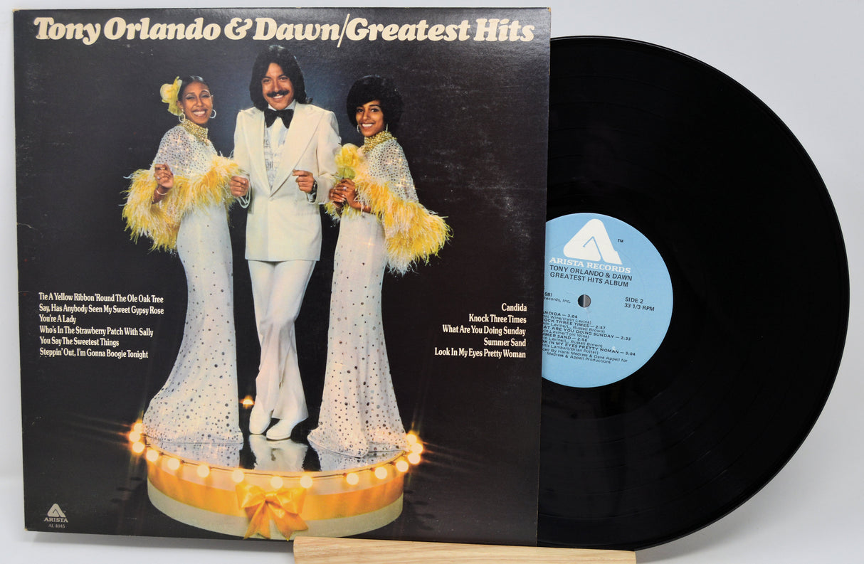 Vinyl record with cover featuring three people and text 'Tony Orlando & Dawn Greatest Hits'.