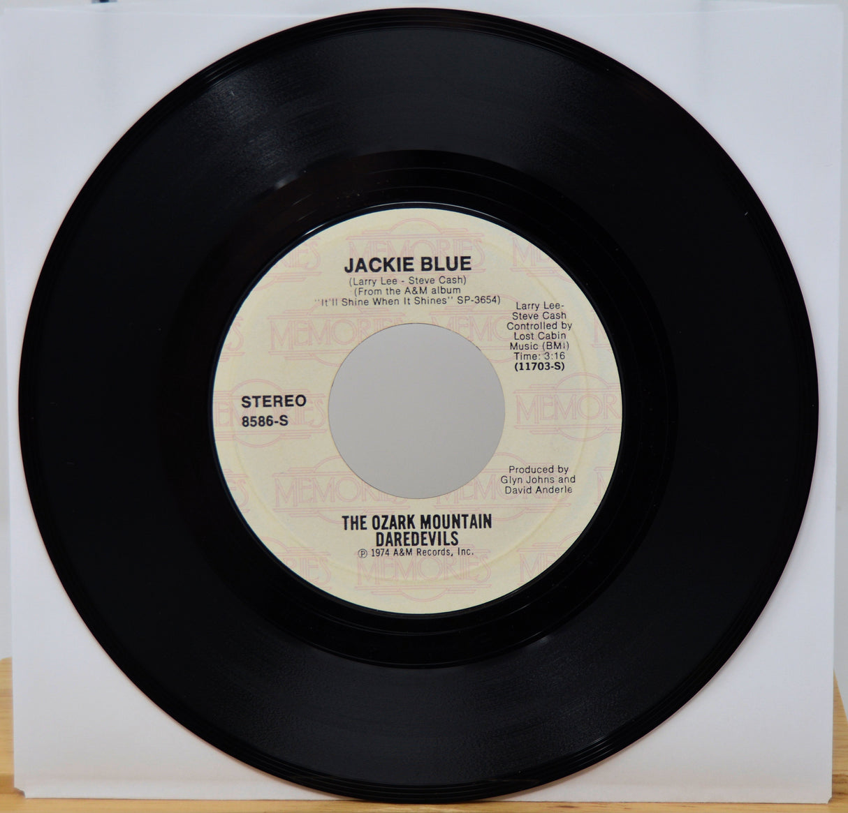Vinyl record with 'Jackie Blue' by The Ozark Mountain Daredevils on a white background