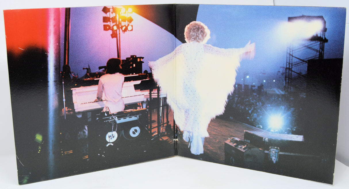 Album cover with two people on a stage, one playing piano and the other in a white outfit.