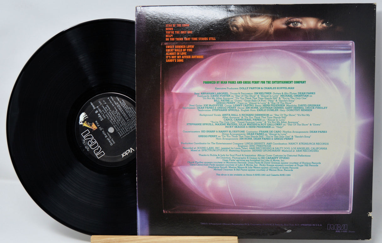 Vinyl record with cover featuring text and a face, on a light gray background