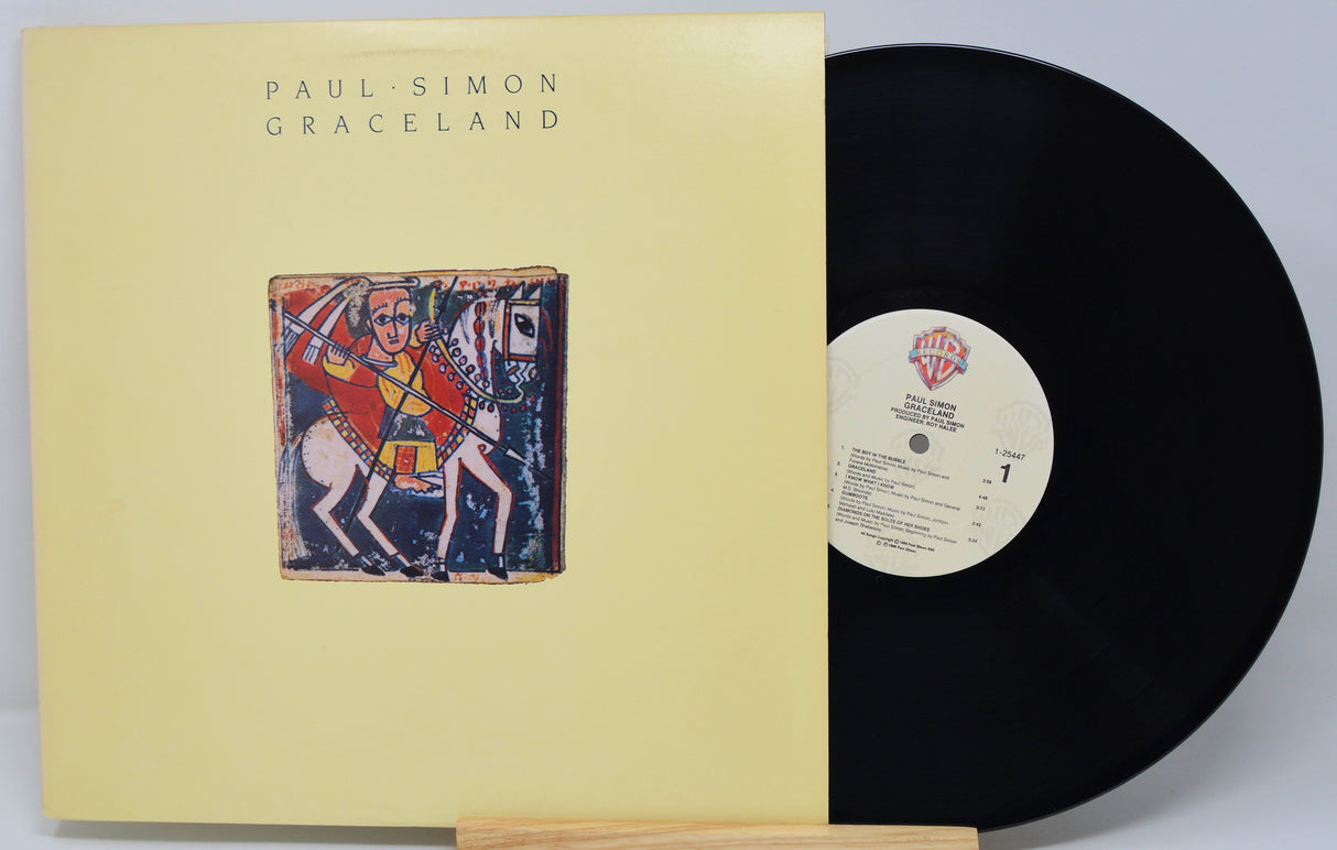 Vinyl record and cover for 'Graceland' by Paul Simon on a light gray background