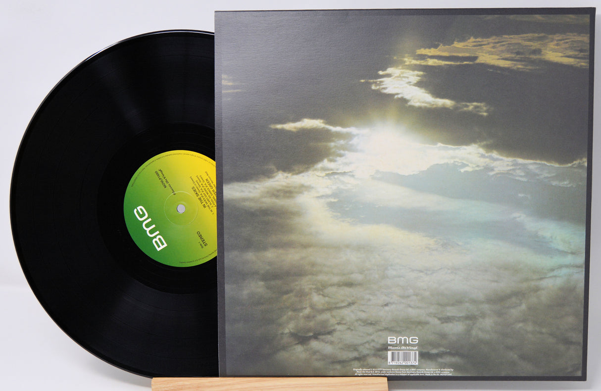 A black vinyl record partially pulled from its sleeve, showing the album cover artwork of clouds with bright sunlight breaking through. The center label and bottom right of the sleeve both show the BMS logo.