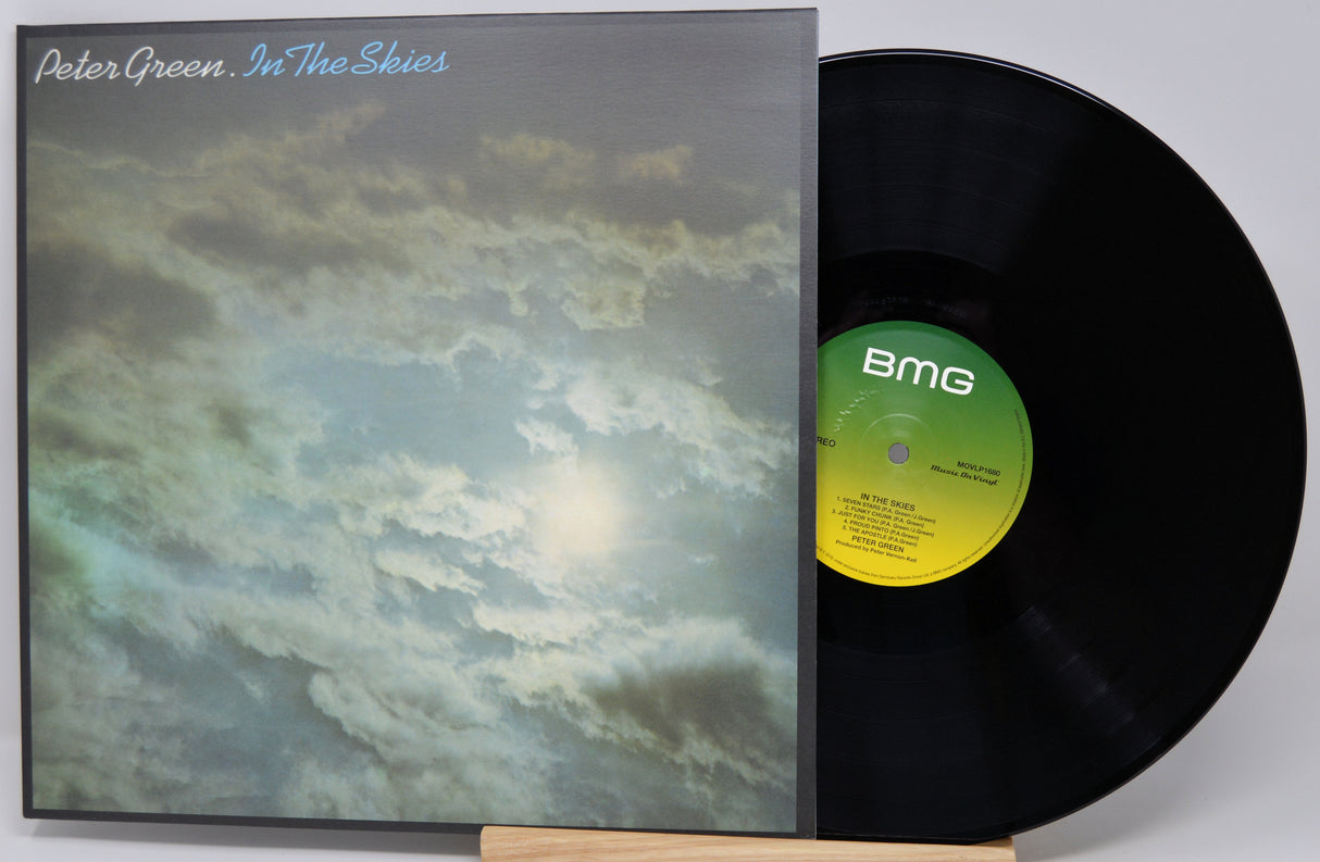 Peter Green - In The Skies vinyl record LP with the album cover standing next to the black vinyl disc on a small wooden easel against a light gray background.