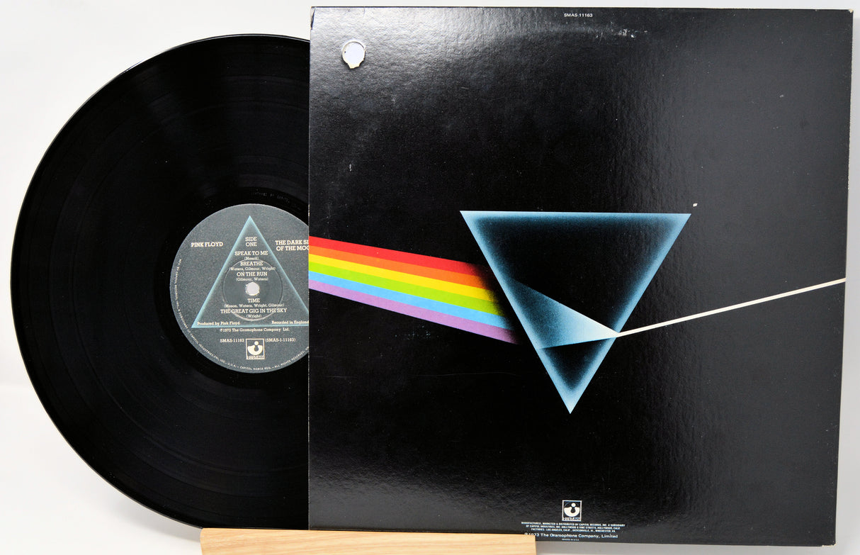 Vinyl record with a black cover featuring a blue triangle and rainbow, on a white background.