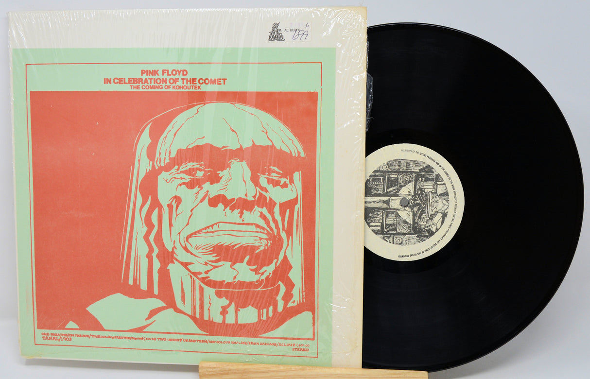 Vinyl record with a cover featuring a stylized face design on a red background.