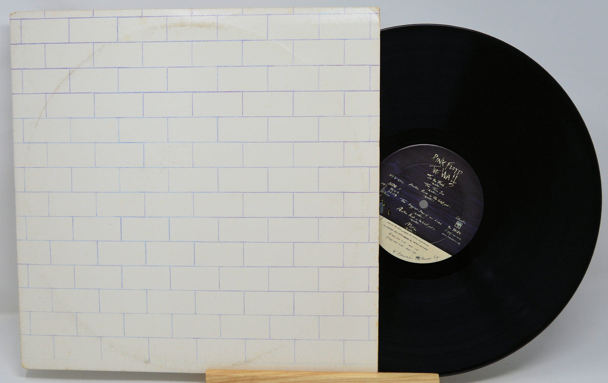 Vinyl record with a white cover featuring a brick pattern on a gray background