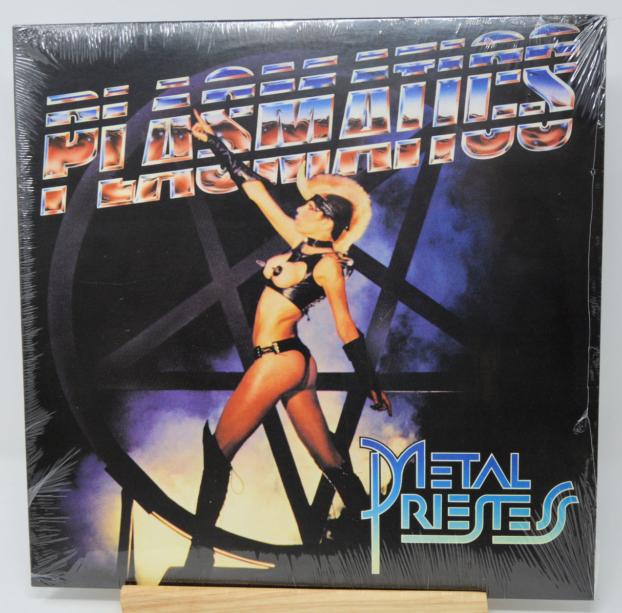 Vinyl record cover with a woman in a bikini and text 'Metal Priests' on a black background