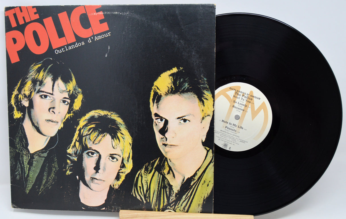 Vinyl record and cover of 'The Police' album 'Outlandos d'Amour' on a light gray background