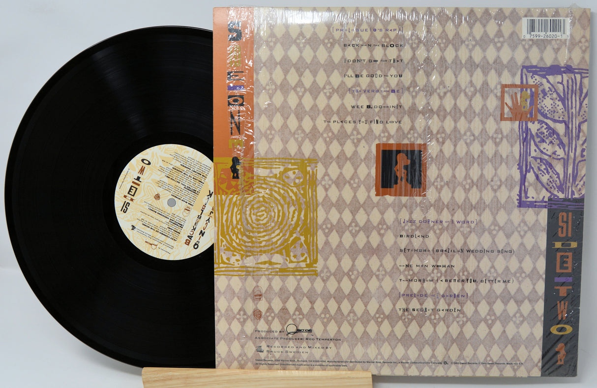 Vinyl record with a detailed cover featuring text and graphics on a light gray background