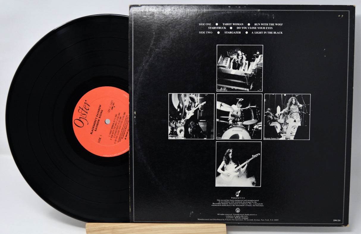 Vinyl record with a black cover featuring black and white images and a red label.