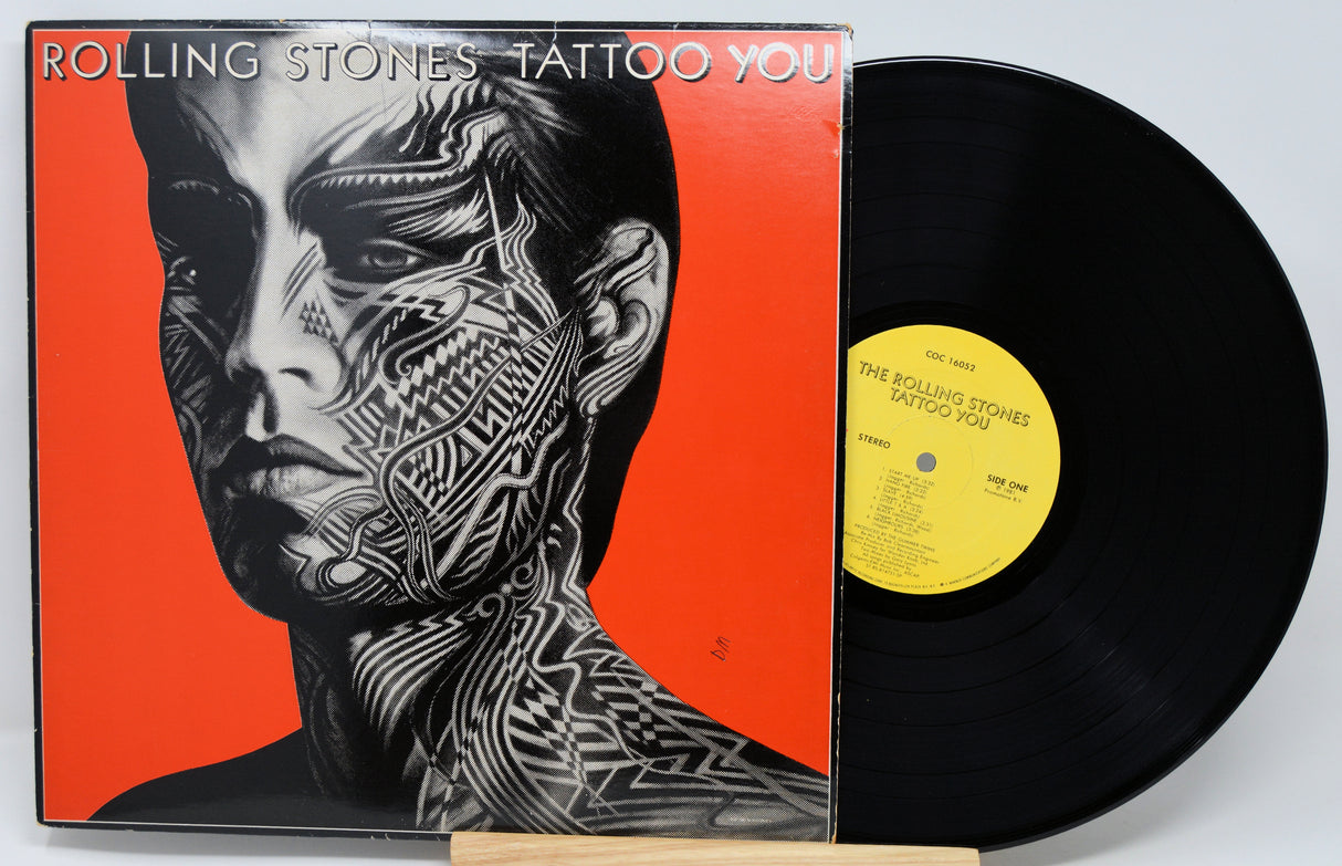 Vinyl record with cover featuring a stylized face and 'Rolling Stones Tattoo You' text.