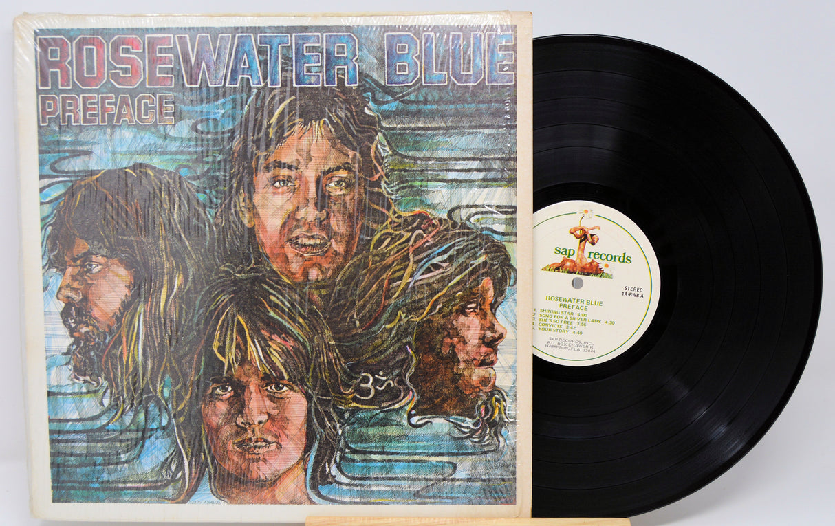 Vinyl record with 'Rosewater Blue' album cover featuring faces and 'sap Records' label.