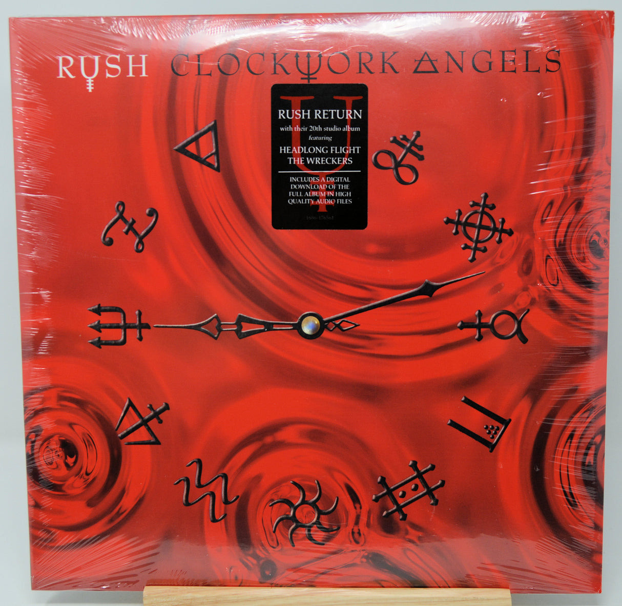 Rush 'Clockwork Angels' vinyl record album cover displayed flat, wrapped in protective plastic with a cardboard insert visible at the bottom.