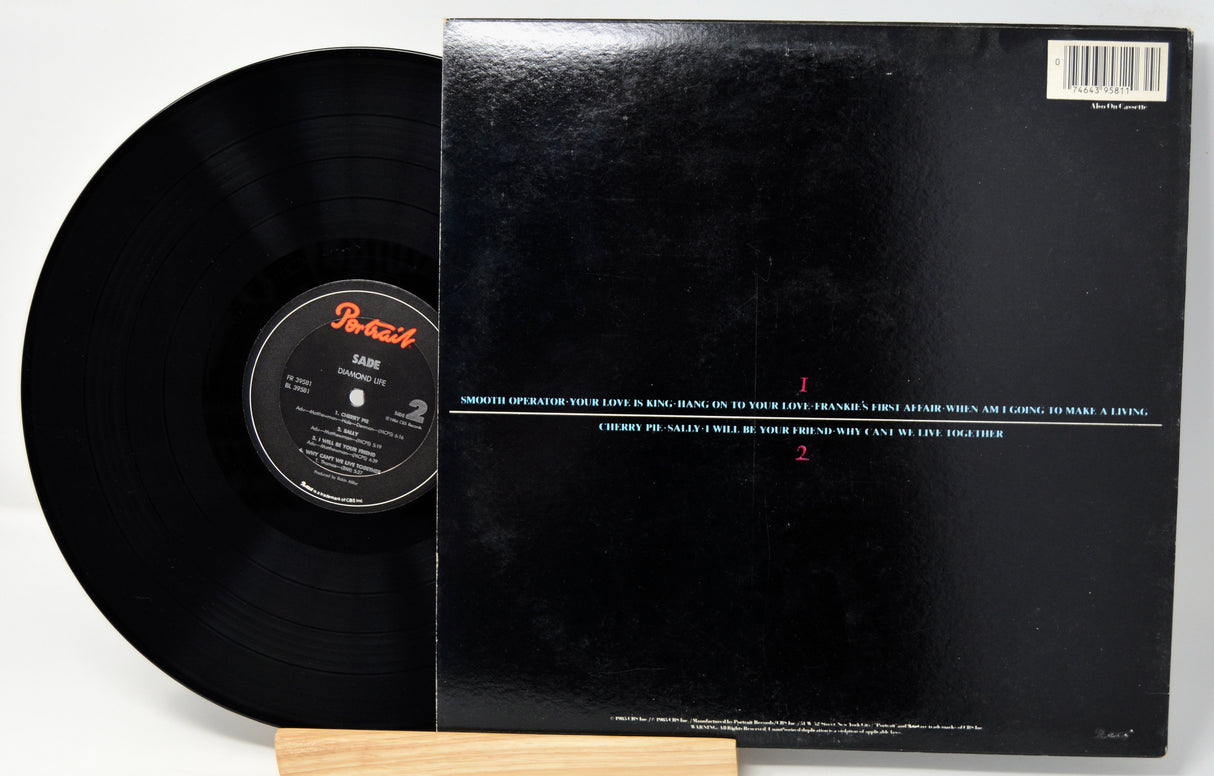 Back cover of Sade vinyl record Diamond all black with song titles in text and a upc barcode.