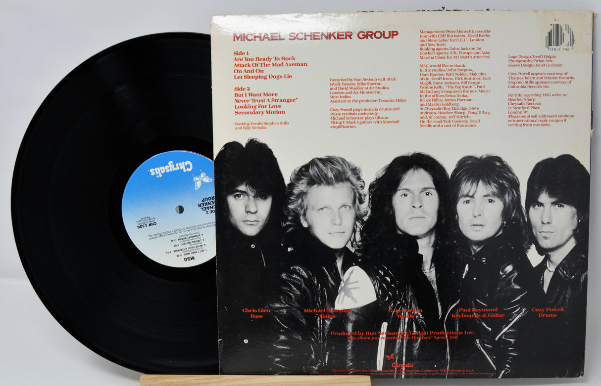Vinyl record with cover featuring a band lineup and text on a gray background