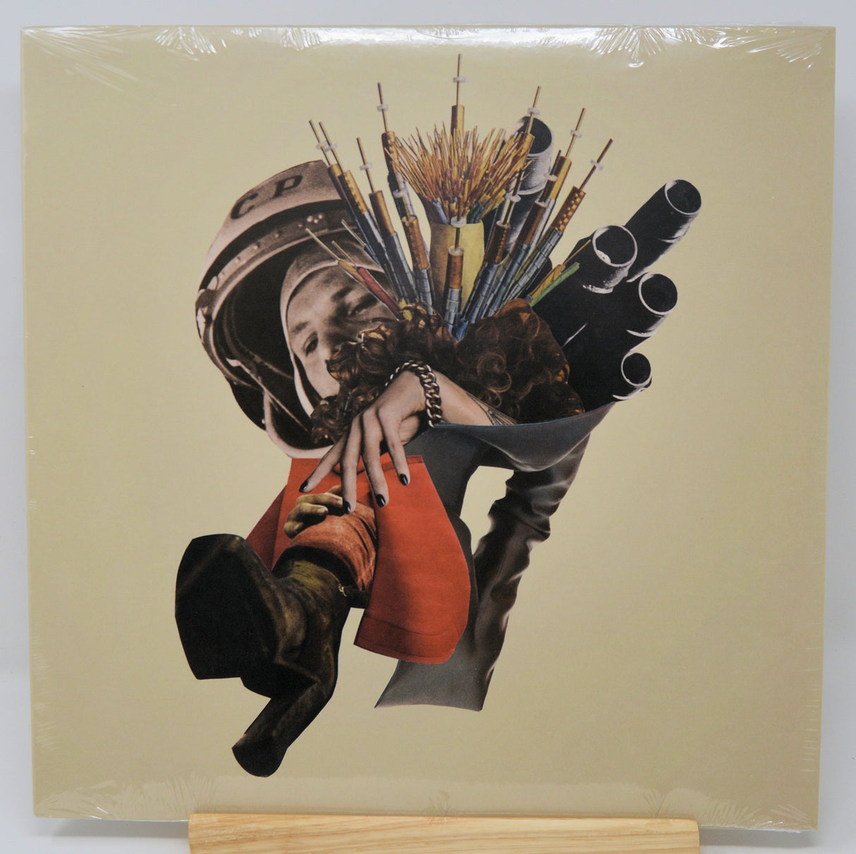 Collage art on a beige background with a person holding boxing gloves and a helmet.