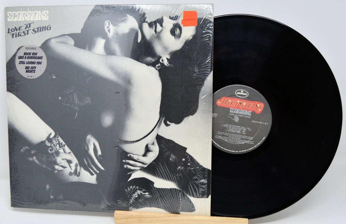 Vinyl record with a colorful cover featuring images of a person playing guitar and sitting.