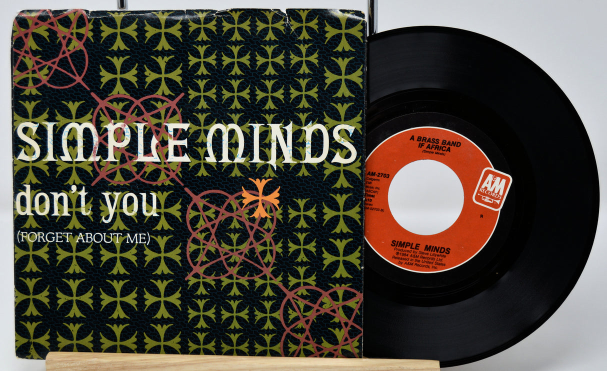 Vinyl record with 'Simple Minds' album cover featuring a geometric pattern.
