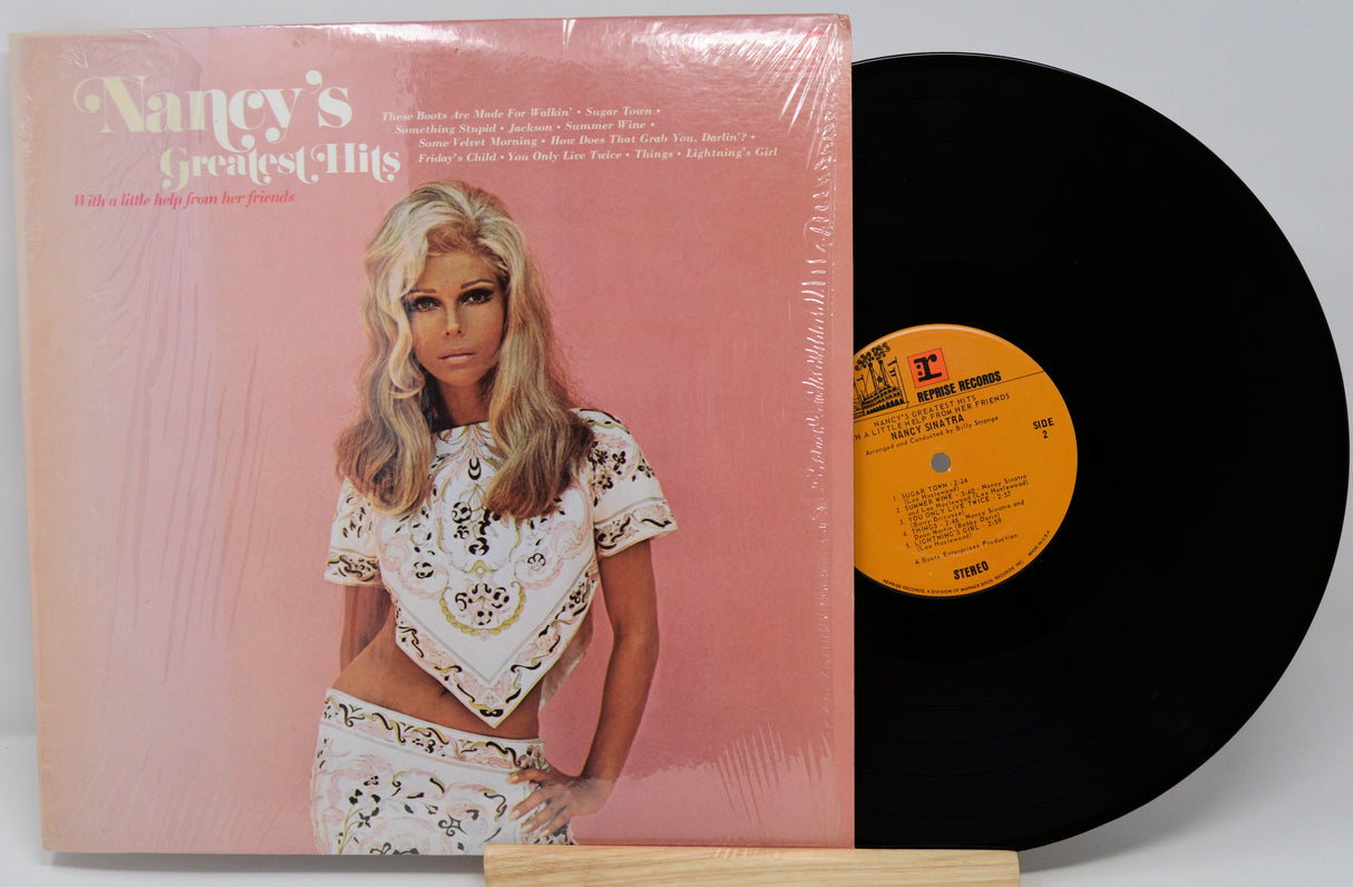 Vinyl record with cover featuring a woman on a pink background