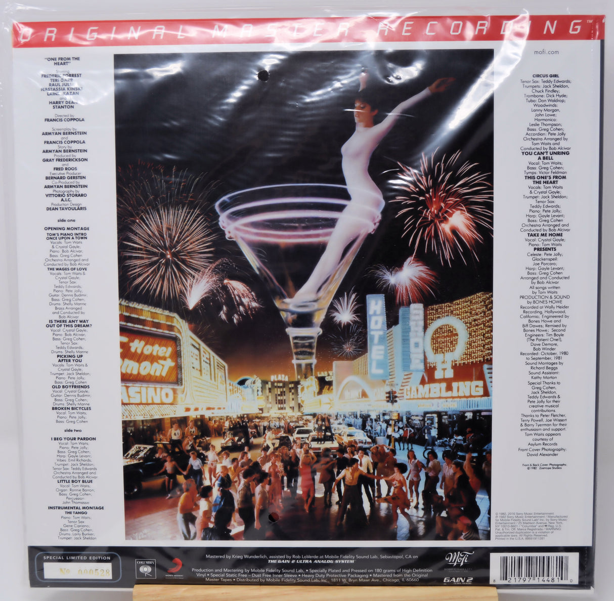 Vinyl record album cover for 'The Wedding Singer' on a white background, showing the back of the sleeve with track listings and the central artwork of a woman in a white dress floating above a Las Vegas street scene with fireworks and a martini glass.
