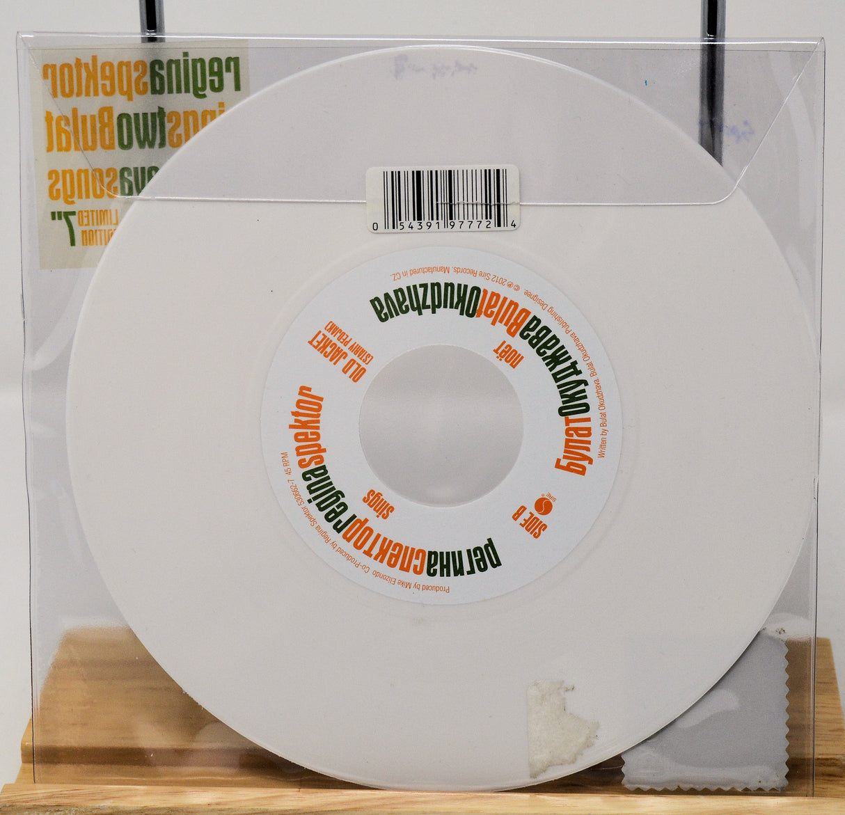 White vinyl record with a label on a wooden surface