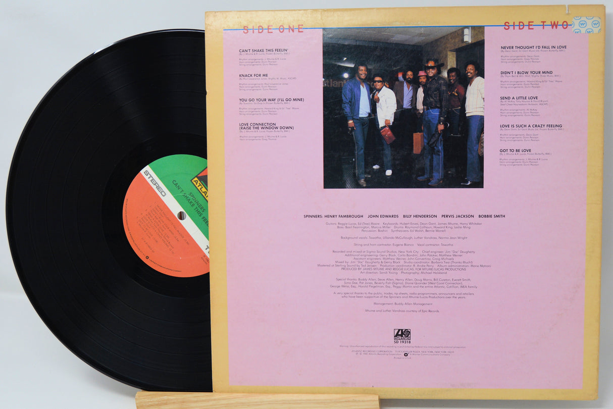 Vinyl record with pink label featuring a group photo and text