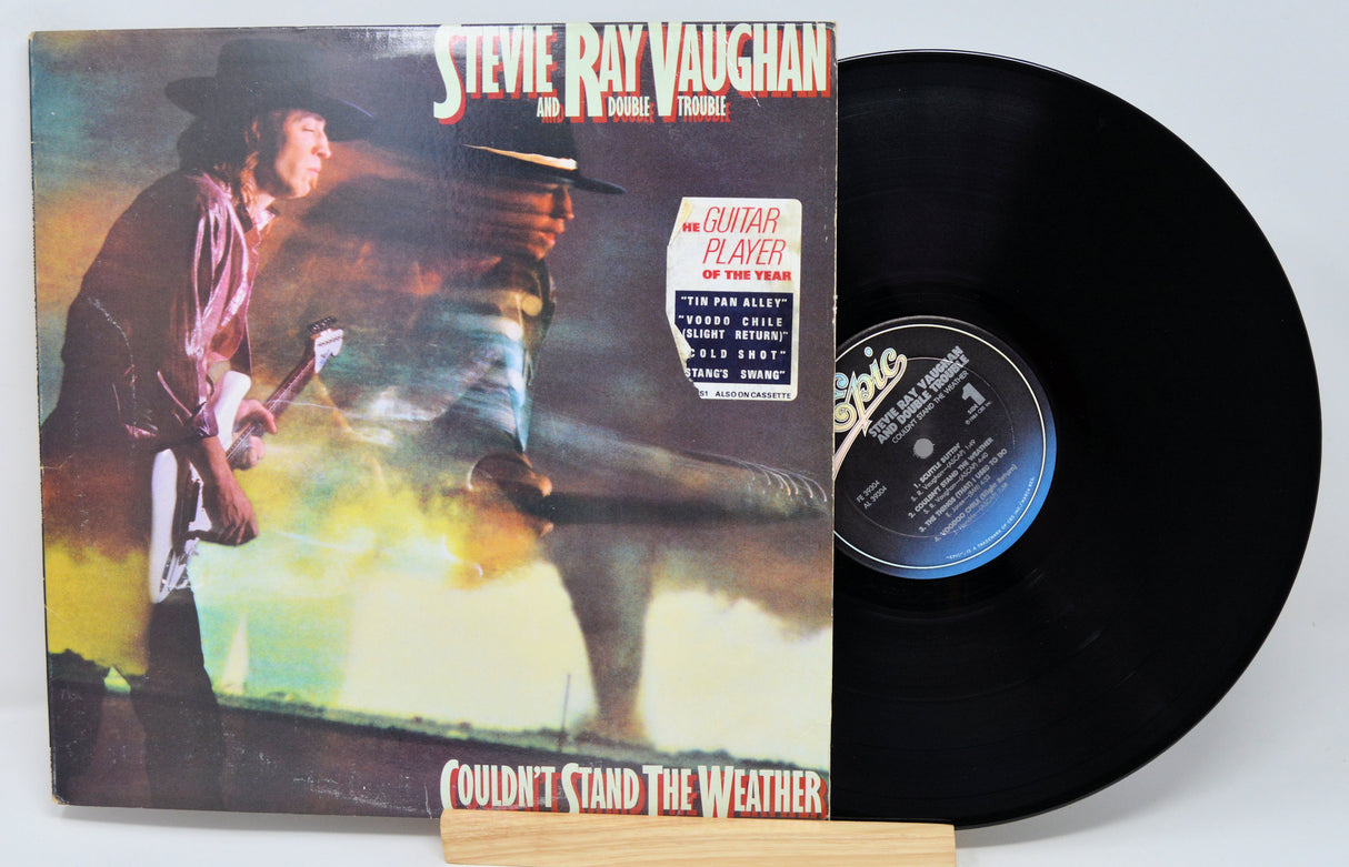 Vinyl record with front cover featuring a musician and album title 'Couldn't Stand the Weather' by Steve Ray Vaughan.