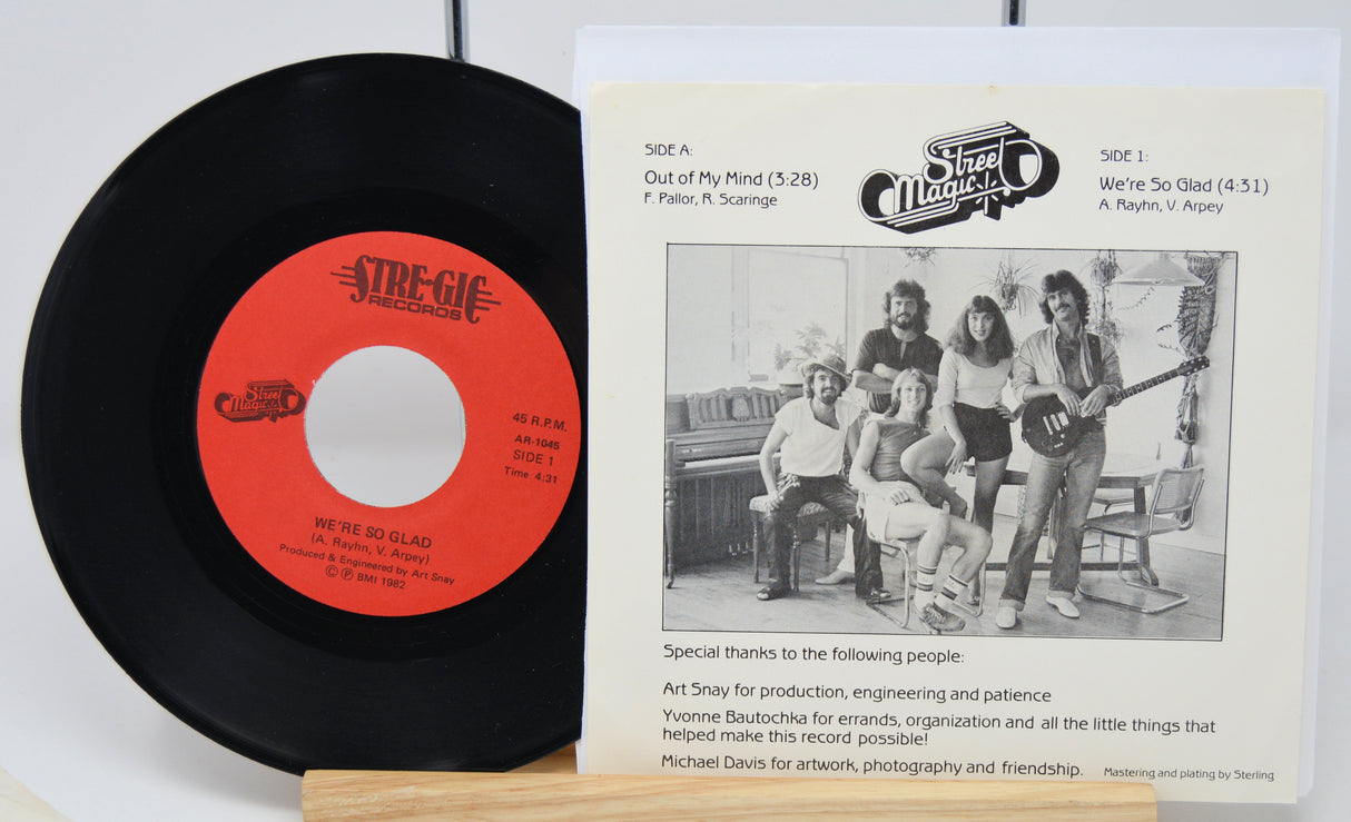 Vinyl record with red label and cover featuring a band photo on a white background