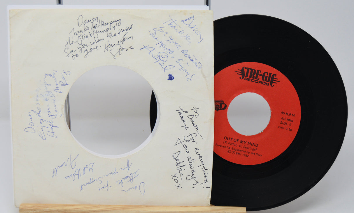 Vinyl record with red label and black disc, signed cover on a white background