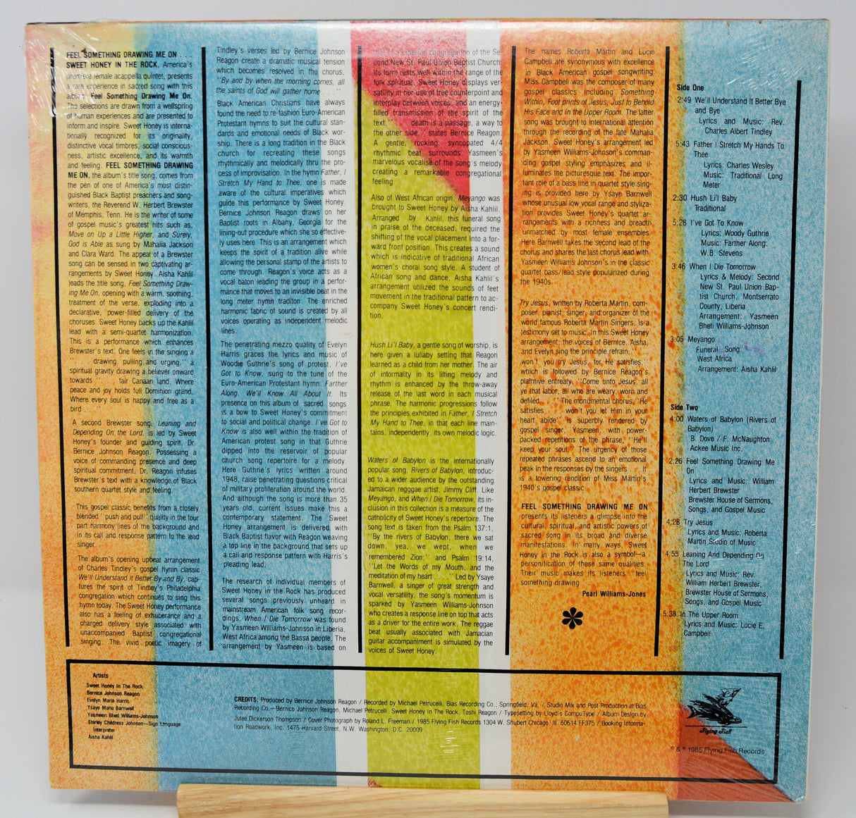 Colorful vinyl record with text and a small four-leaf clover design on a white background