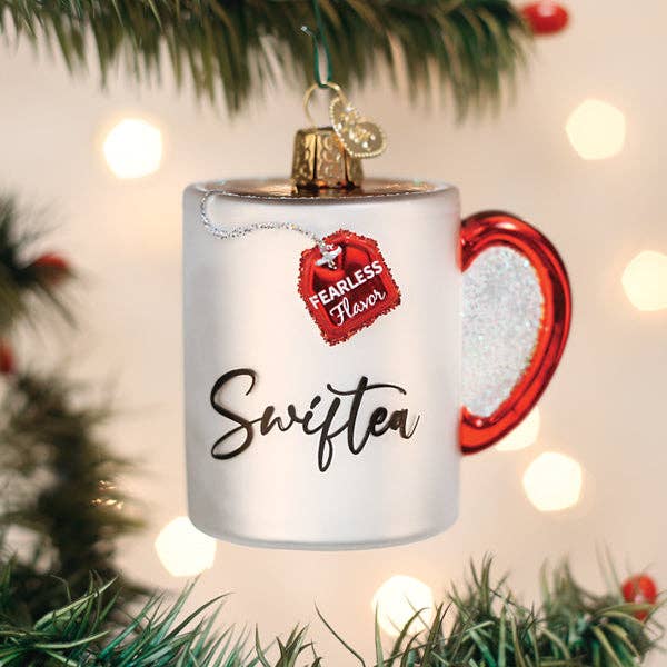 Swiftea mug ornament hanging on a Christmas tree with glowing lights