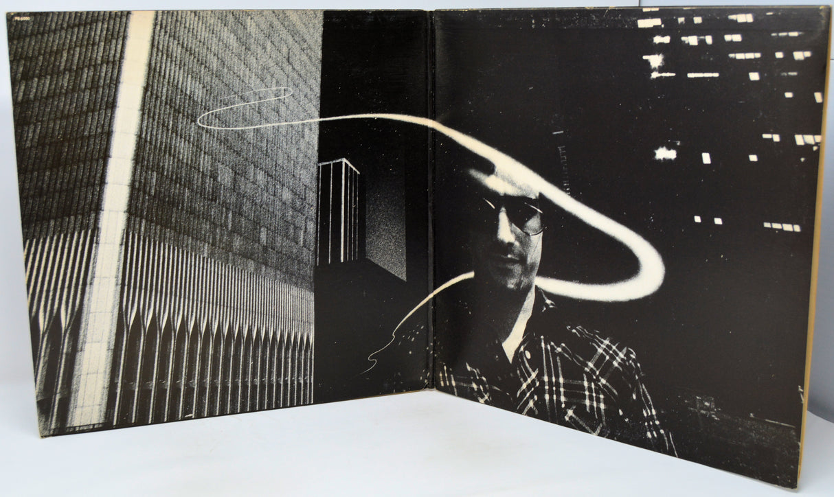 Open book with black and white images of a cityscape and a person.