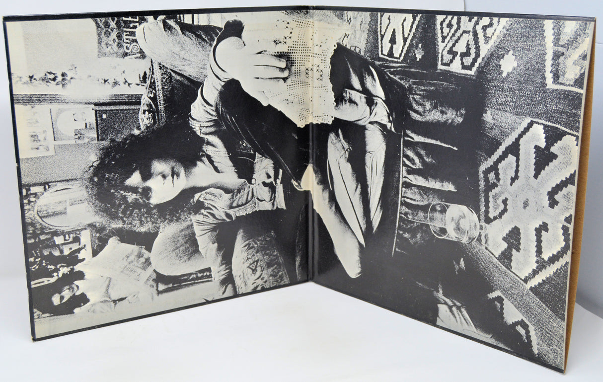 Open book with black and white photographs of people in a room.