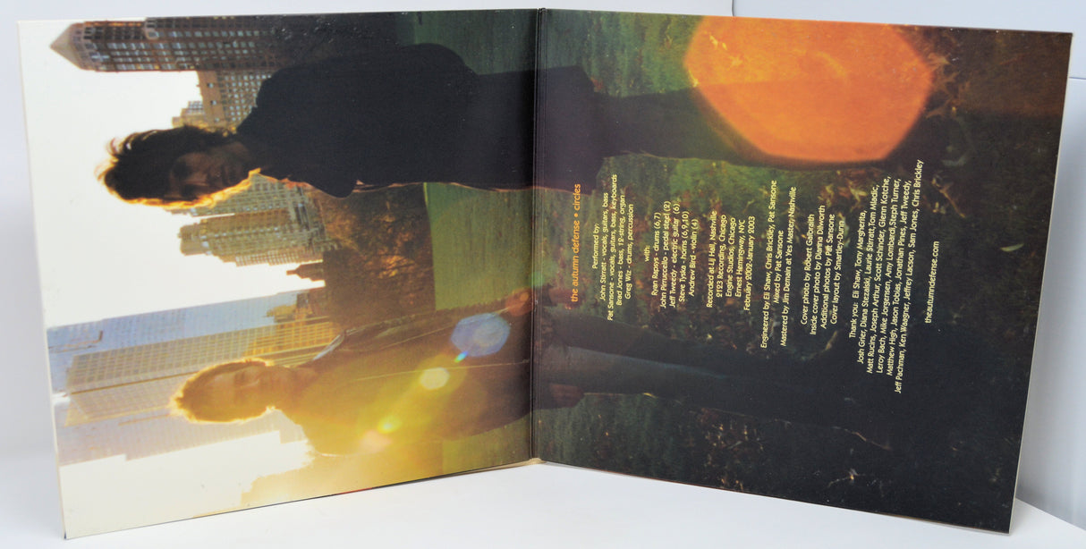 Inner gatefold of The Autumn Defense Circles album with credits and band photo in a sunlit city park