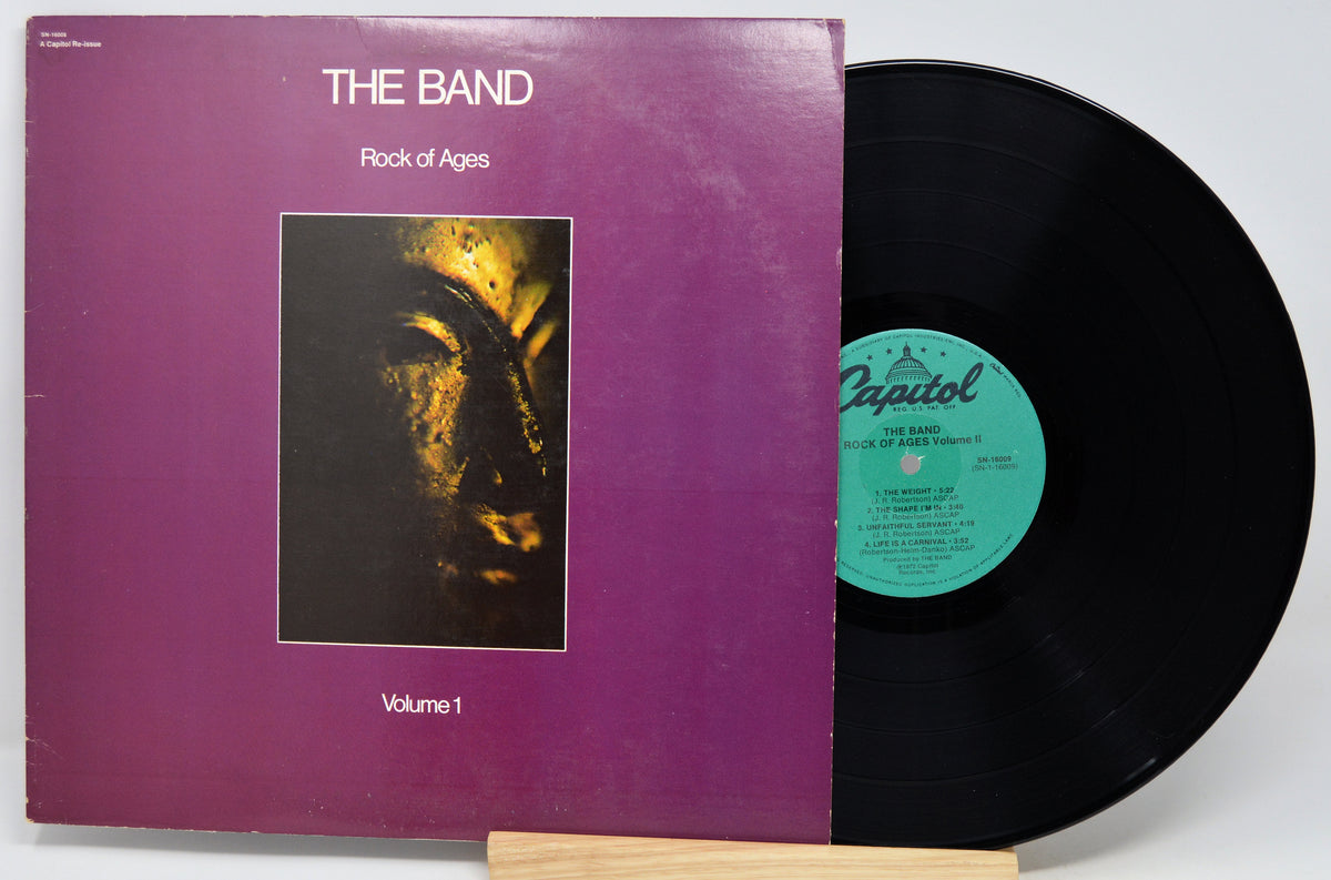 The Band's 'Rock of Ages' vinyl record album, Volume 1, with the purple cover jacket and a black LP partially pulled from the sleeve, showing the Capitol record label.