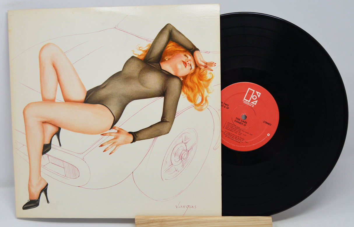 Used vinyl record of The Cars - Candy-O with the album cover showing a sketch of a sexy red headed woman lying across the hood of a car.