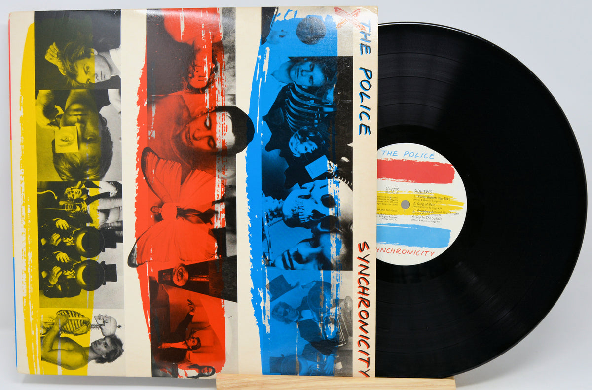 The Police 'Synchronicity' vinyl record LP with its illustrated outer sleeve partially covering the black record, photographed on a light gray background.