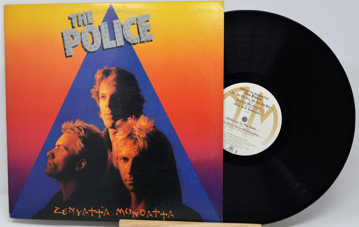 Vinyl record with 'The Police' album cover featuring band members and a colorful design.