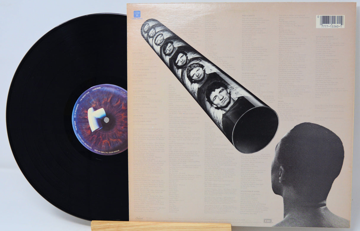 Vinyl record with a stylized cover featuring faces and a person's silhouette.