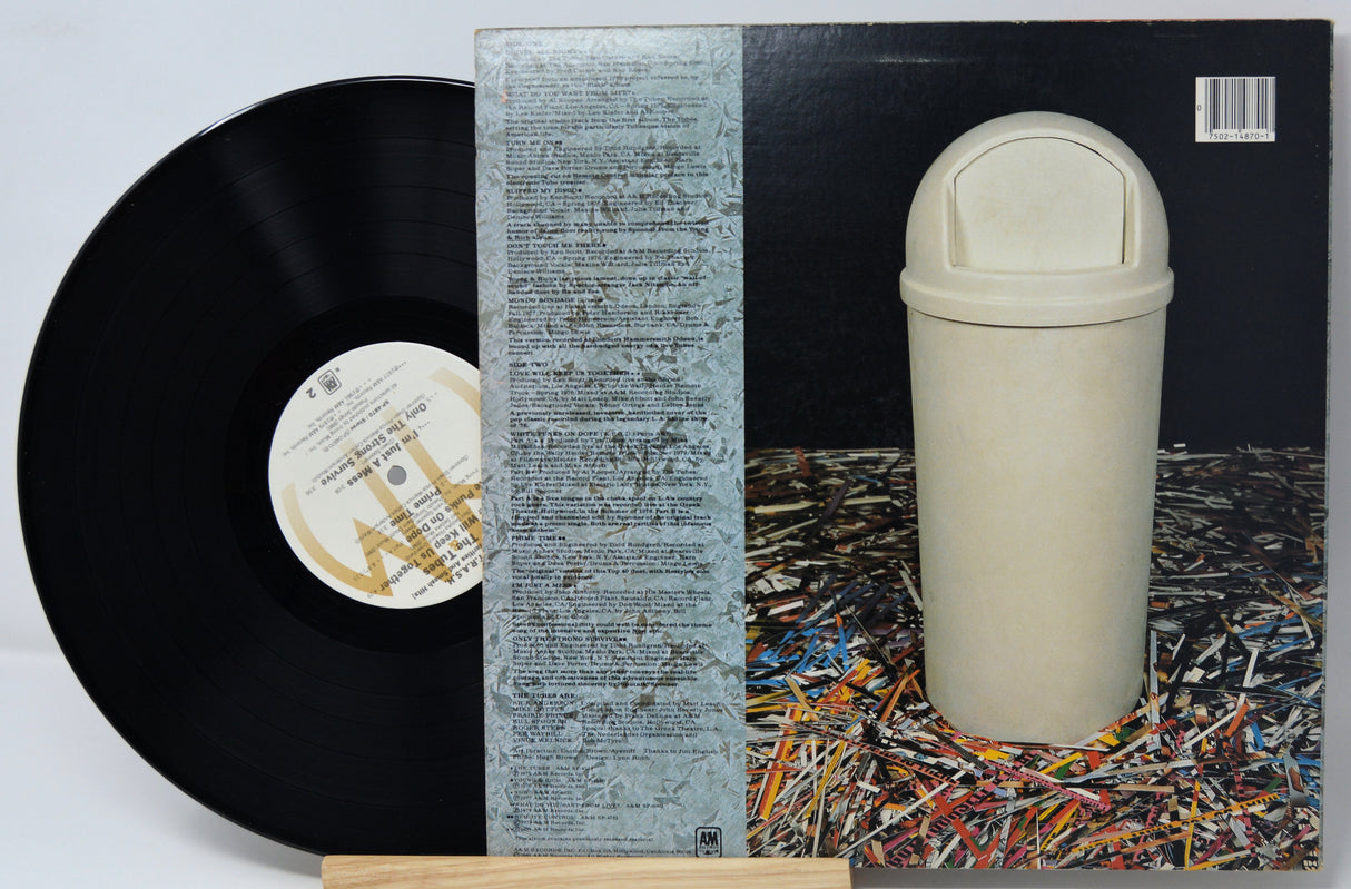 Vinyl record with a unique cover featuring a white cylindrical object on a textured background.