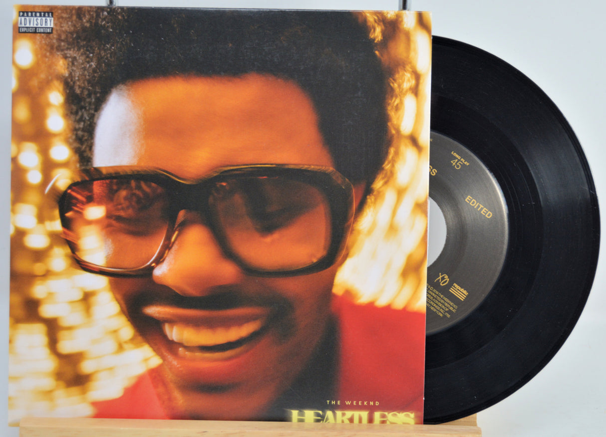 Vinyl record cover featuring The Weeknd wearing sunglasses against a blurred light background for the song Heartless