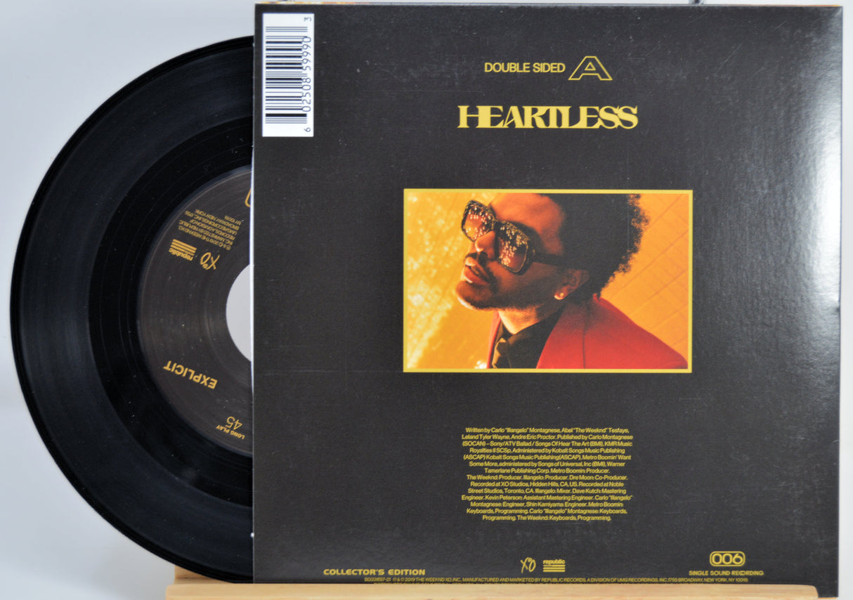 The Weeknd 7 Inch Vinyl record for 'Heartless' back cover featuring a person with glasses on a yellow background.