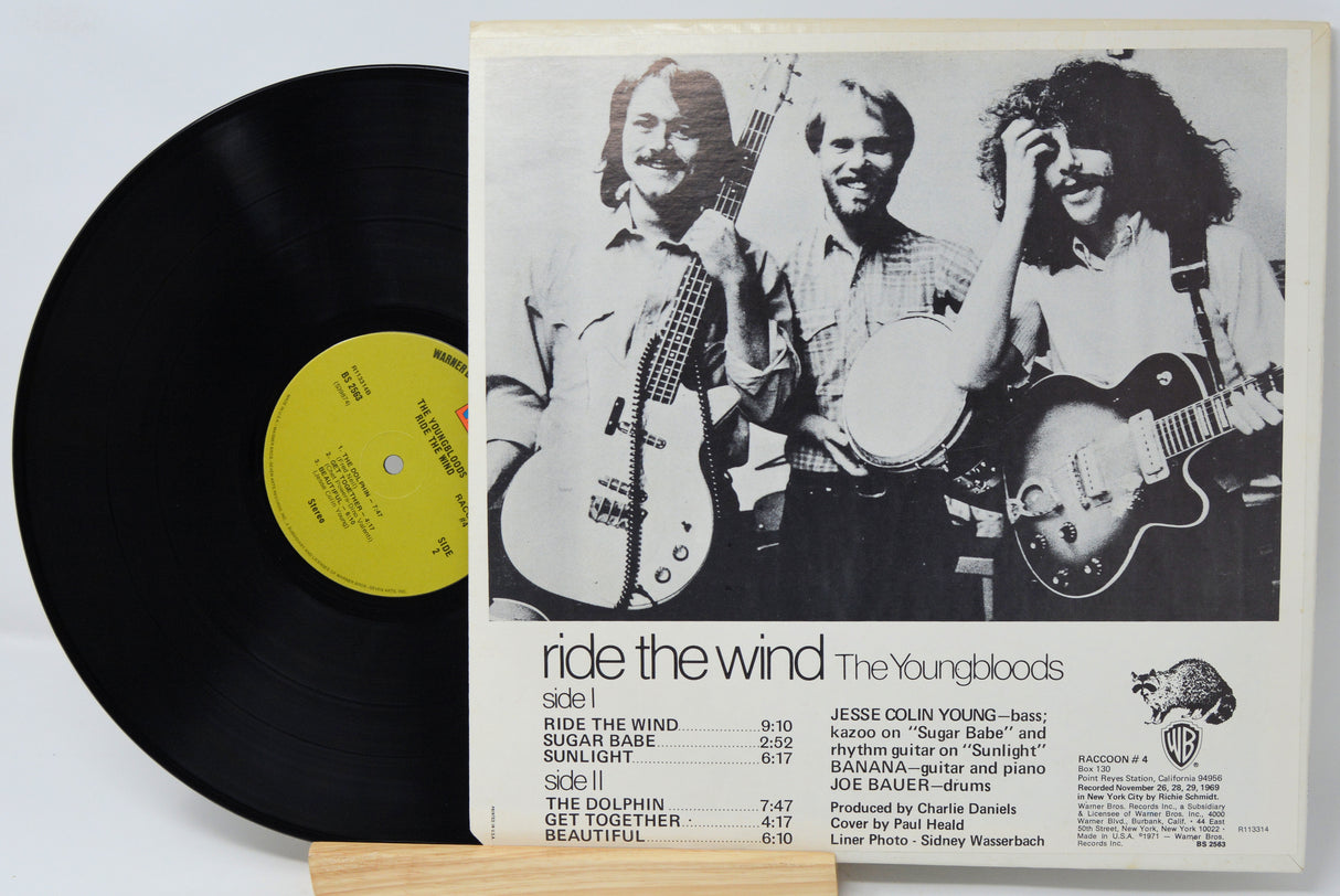 Vinyl record with a cover featuring a band and album details on a white background
