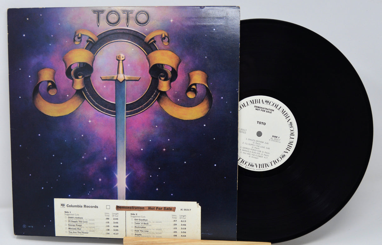 Vinyl record with a colorful cover featuring the band Toto's logo.