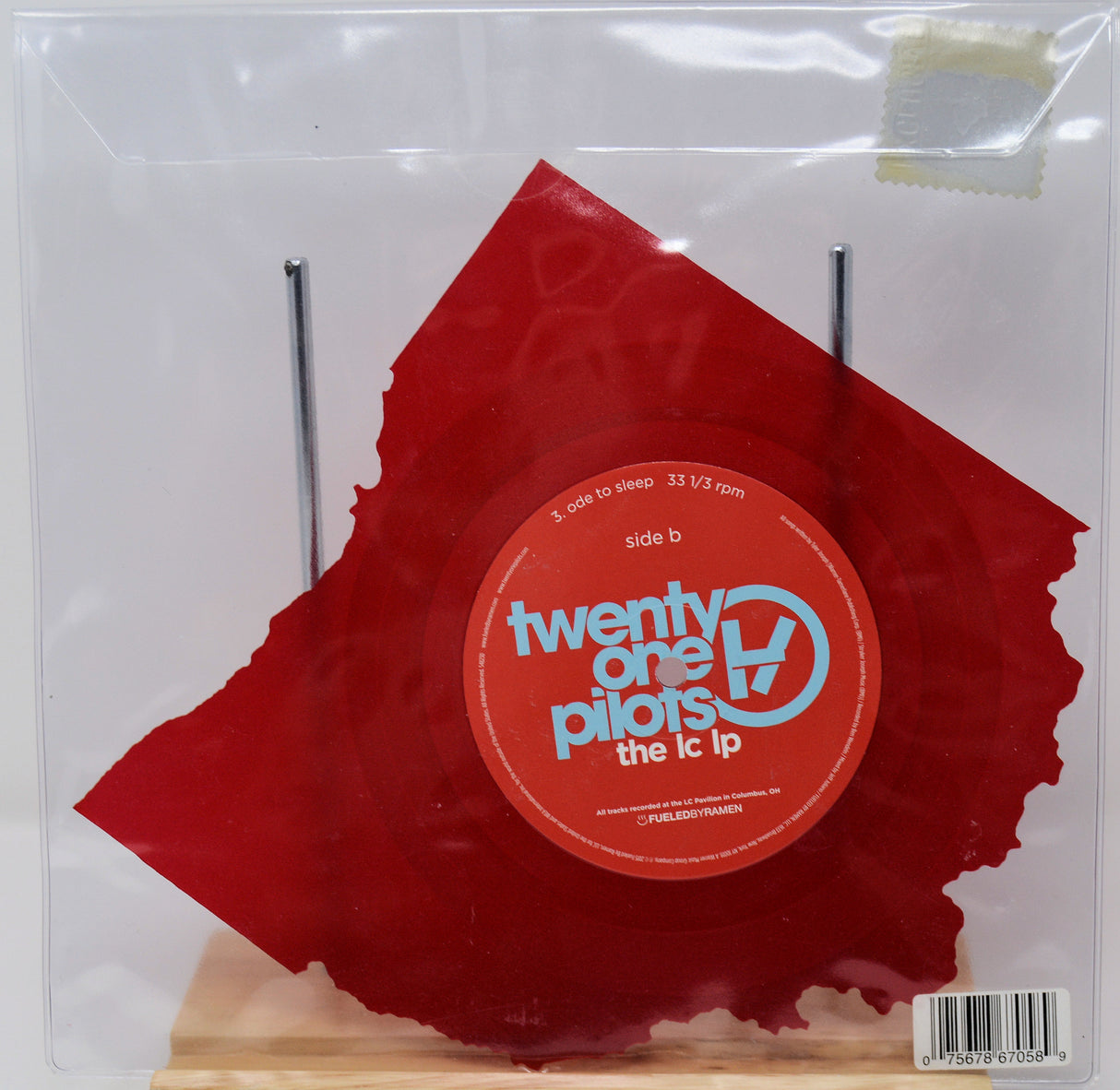 Red vinyl record with 'twenty one pilots' logo on a clear sleeve
