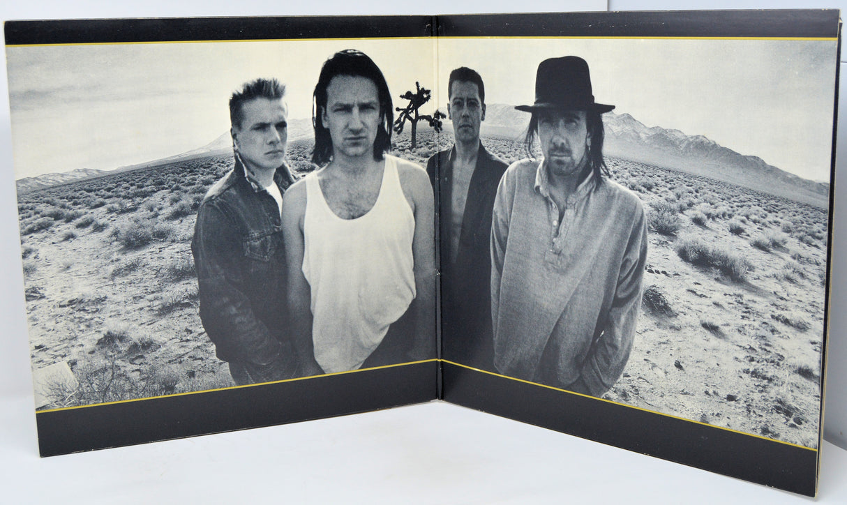 Album cover with a black and white photo of four people in a desert landscape.