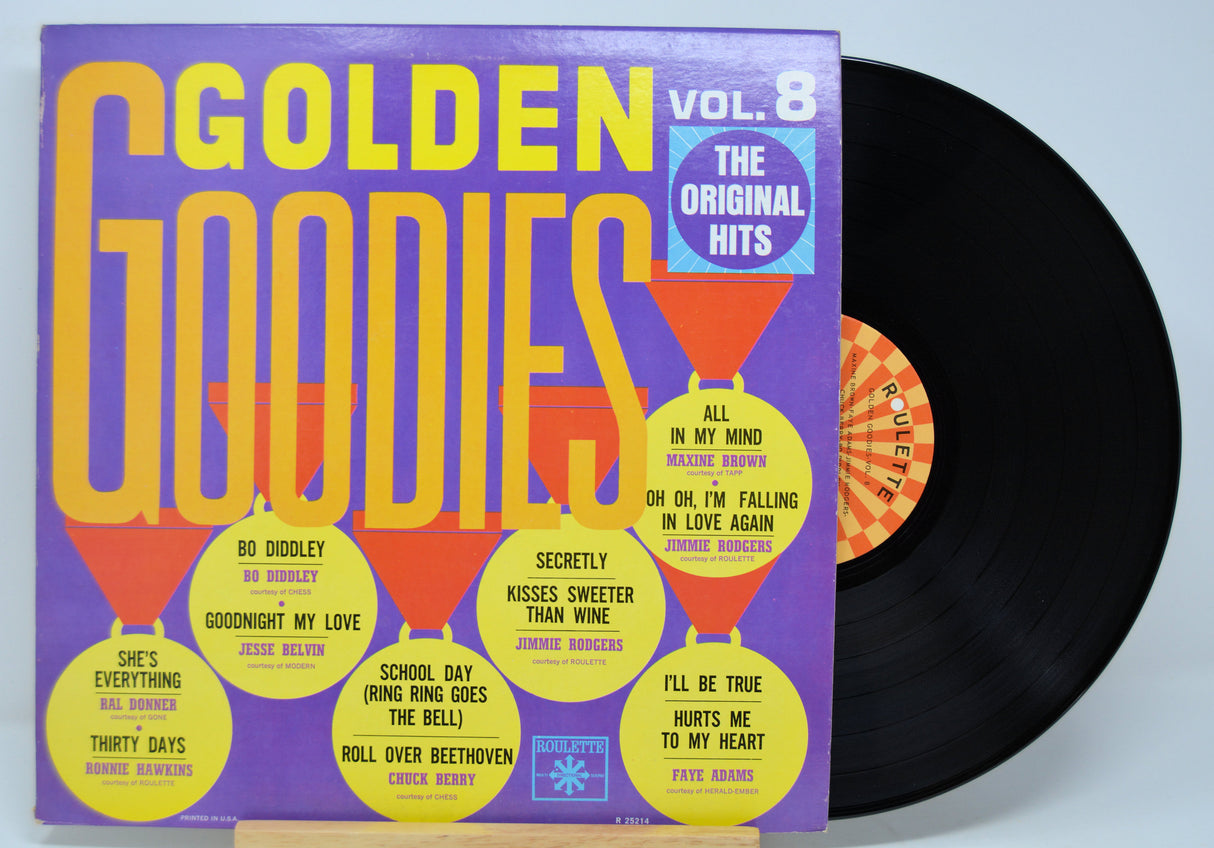 Vinyl record with colorful 'Golden Goodies' album cover on a light blue background