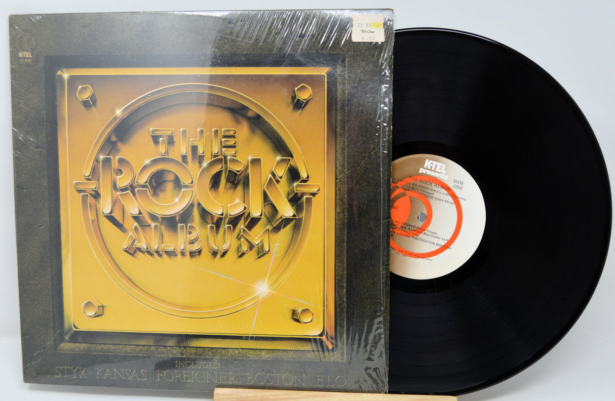 Vinyl record with 'The Rock Album' cover on a white background